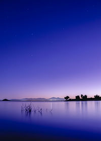 Scenic view of lake against blue sky at night