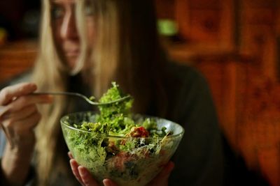 Midsection of woman holding salad bowl