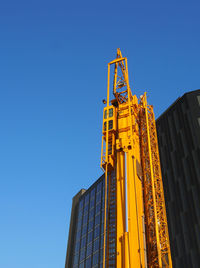 Low angle view of modern building against clear blue sky