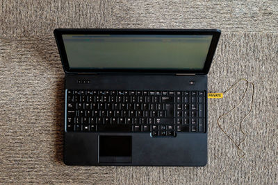 Directly above shot of laptop connected to usb stick on carpet