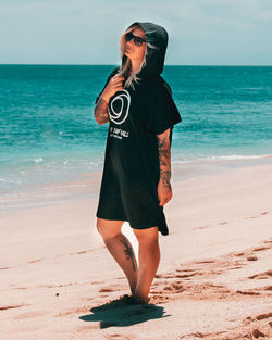 Full length of man wearing sunglasses standing on beach