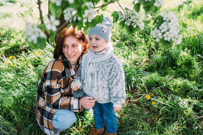 Portrait of young woman standing against plants