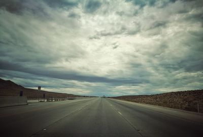 Empty road along countryside landscape