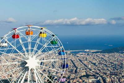 Ferris wheel by sea against sky