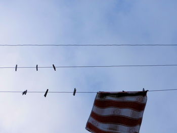 Low angle view of clothesline against blue sky