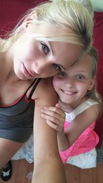 Portrait of smiling mother and daughter at home