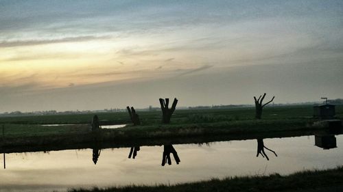 View of field against cloudy sky