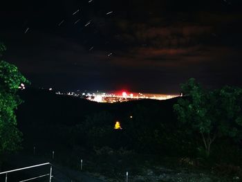 Illuminated city against sky at night