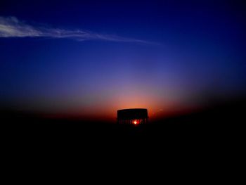 Low angle view of illuminated buildings against sky at sunset