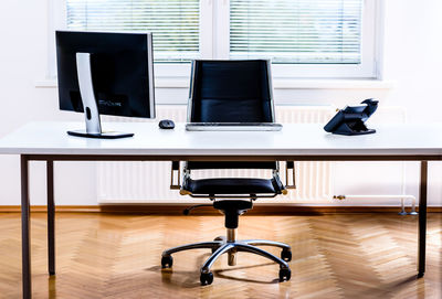 Computer and landline phone on desk in office