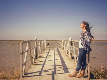 Woman on beach against clear sky