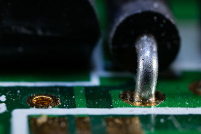 Close-up of water drop on metal grate