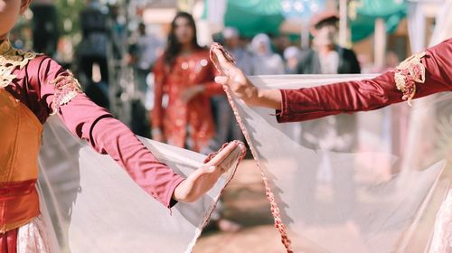 Midsection of couple holding hands