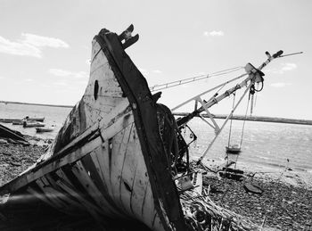 Shipwreck at beach against sky