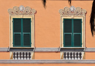 Close-up of a pair of closed windows with the frames decorated with trompe l'oeil painting, liguria