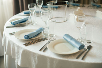 Plates and glasses arranged on table at restaurant