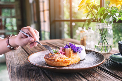 Cropped hand of person holding food on table