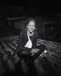 Portrait of smiling girl sitting at night