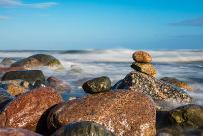 Close-up of pebbles on beach against sky