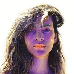 Close-up portrait of woman with face paint against white background