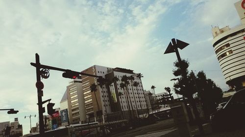 Low angle view of modern building against cloudy sky