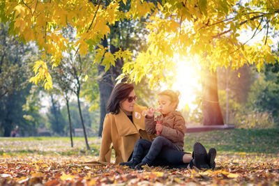 Women sitting on plant during autumn