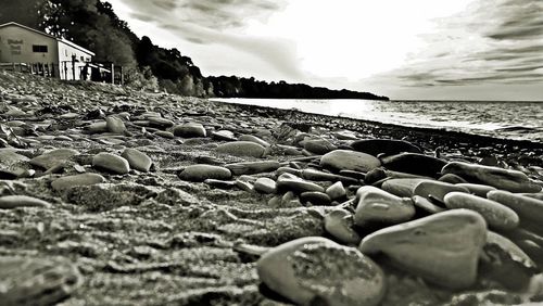 Close-up of pebbles on beach against sky