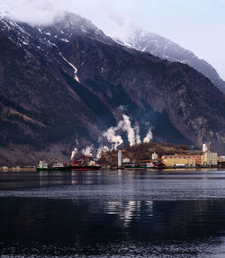 Scenic view of lake by buildings against sky