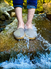 Low section of man standing on rock