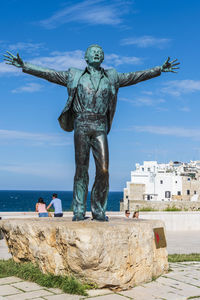 Domenico modugno. mr volare. polignano a mare sunlit. puglia. italy