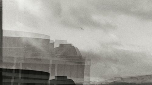 Low angle view of modern building against cloudy sky