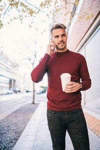 Full length of young man using mobile phone