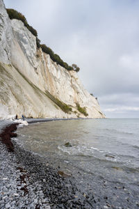 Surface level of rocks on shore against sky