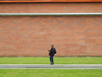 Rear view of man walking on wall