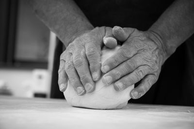 Close-up of man holding hands on table