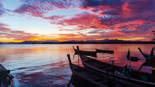 Boat moored in sea against sky during sunset