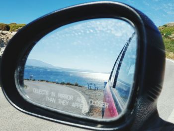 Reflection of sky on side-view mirror of car