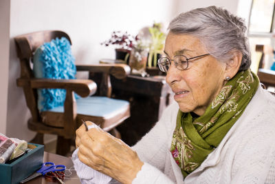 Senior woman sewing mask at home