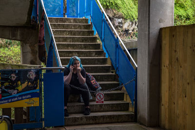 Portrait of young woman sitting on staircase