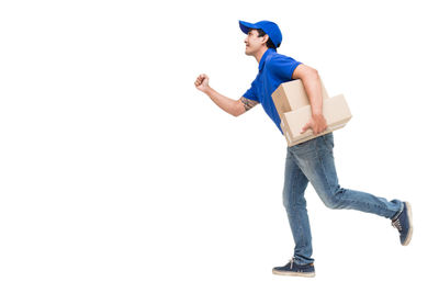 Salesman with cardboard boxes running against white background