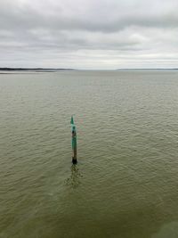 Rear view of man in sea against sky