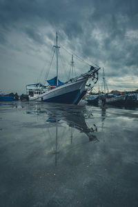 Sailboats moored on sea against sky