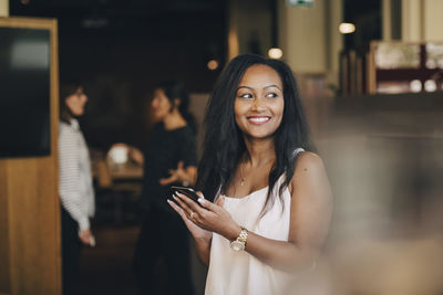 Portrait of smiling young woman using smart phone