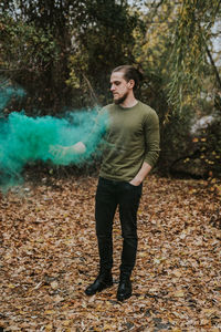 Full length of young man standing in forest