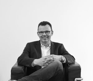 Portrait of smiling man sitting against white background