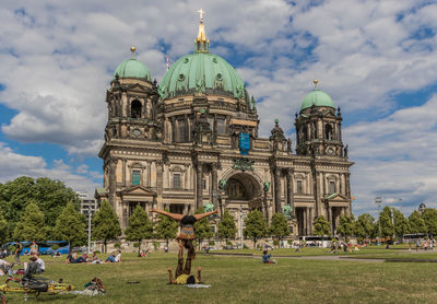 Group of people in front of cathedral against sky