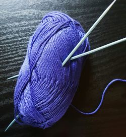 Close-up of knitting needles with wool on table