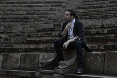 Thoughtful young man sitting on steps 