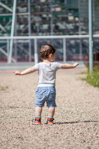 Rear view of boy standing on street