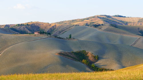 Scenic view of sand dunes against sky